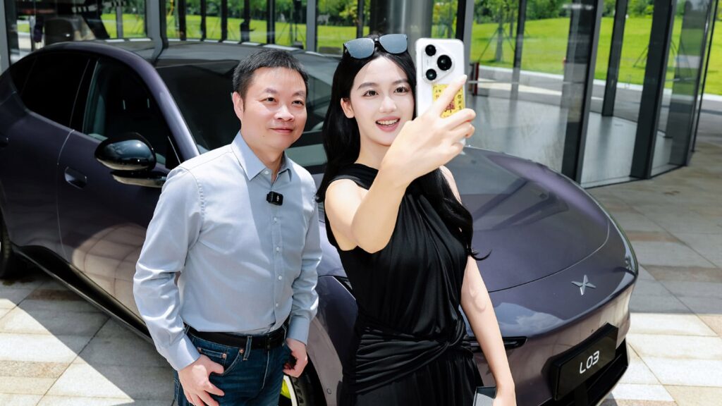 Xpeng delivers first Mona L03 SUVs in China, plans nationwide ramp-up in August He Xiaopeng (left), chairman and CEO of Xpeng, poses for a photo with a Mona L03 owner.