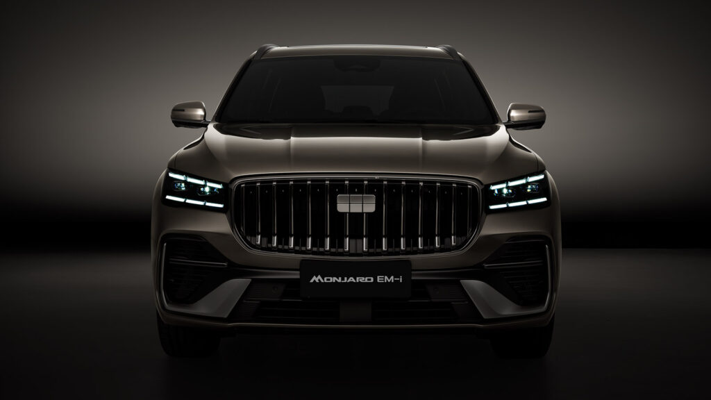 Front view of the Geely Monjaro EM-i hybrid SUV with its LED headlights illuminated and a large vertical-slat grille.