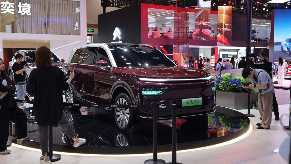 A burgundy Epicland X9 SUV on display as visitors take photos at the 2026 Beijing auto show.