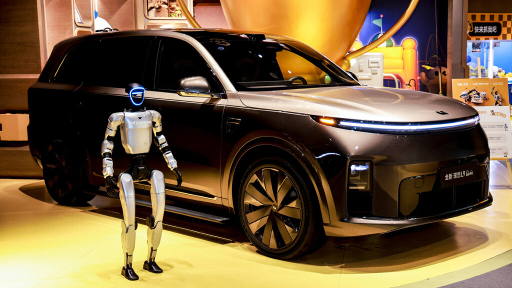 A Unitree humanoid robot stands beside a Li L9 Livis on display at the Beijing Auto Museum.