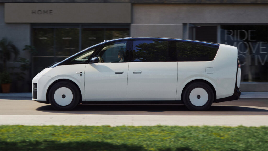 Side view of the next-generation Li Mega electric MPV driving past storefronts.