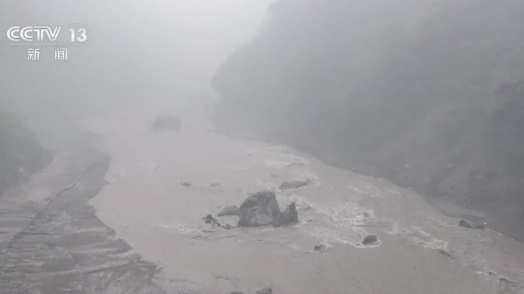 Muddy floodwater and debris fill a mountain valley near Gyirong Port in Xizang following a mudslide.