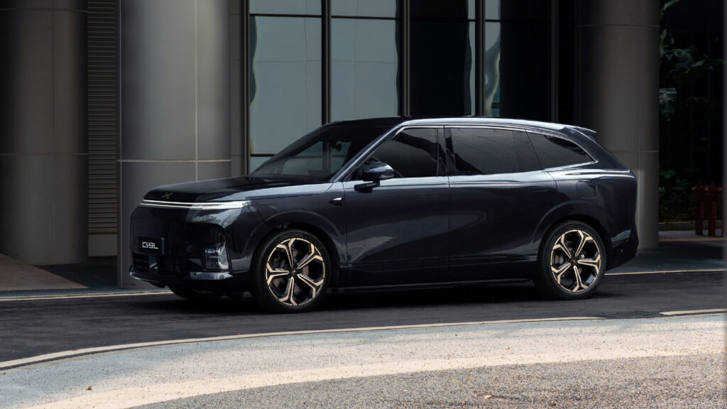 A dark gray Xpeng G9L SUV parked outside a modern building, shown from a front three-quarter angle.