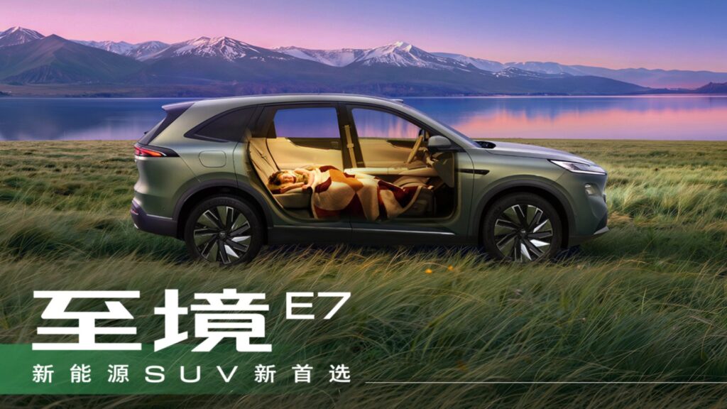 Buick Electra E7 SUV beside a lake, with a cutaway view showing a passenger resting in the cabin.