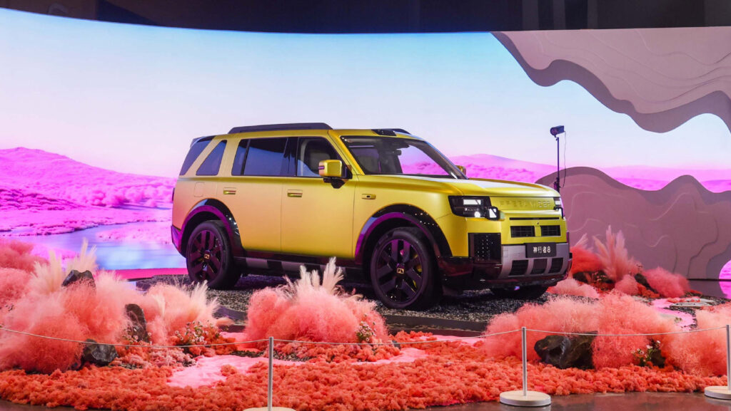 Freelander 8 tops 5,000 firm orders in 12 hours after launch A yellow Freelander 8 displayed on a desert-themed stage with pink lighting and decorative plants.