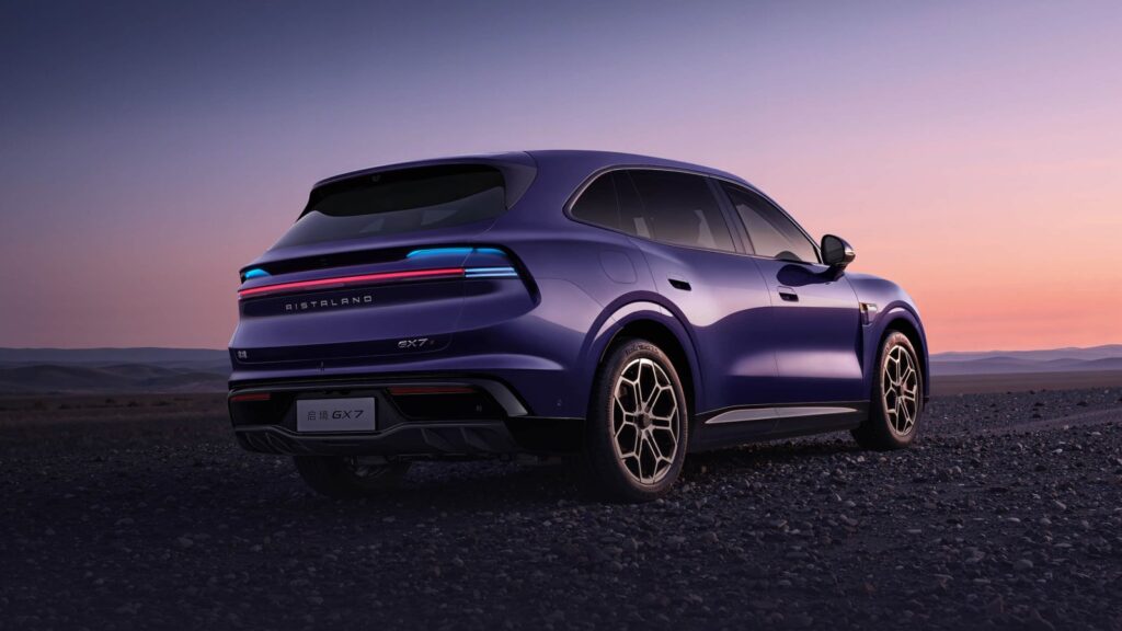 Rear three-quarter view of a purple Aistaland GX7 SUV on rocky terrain at dusk, showing its full-width taillight.