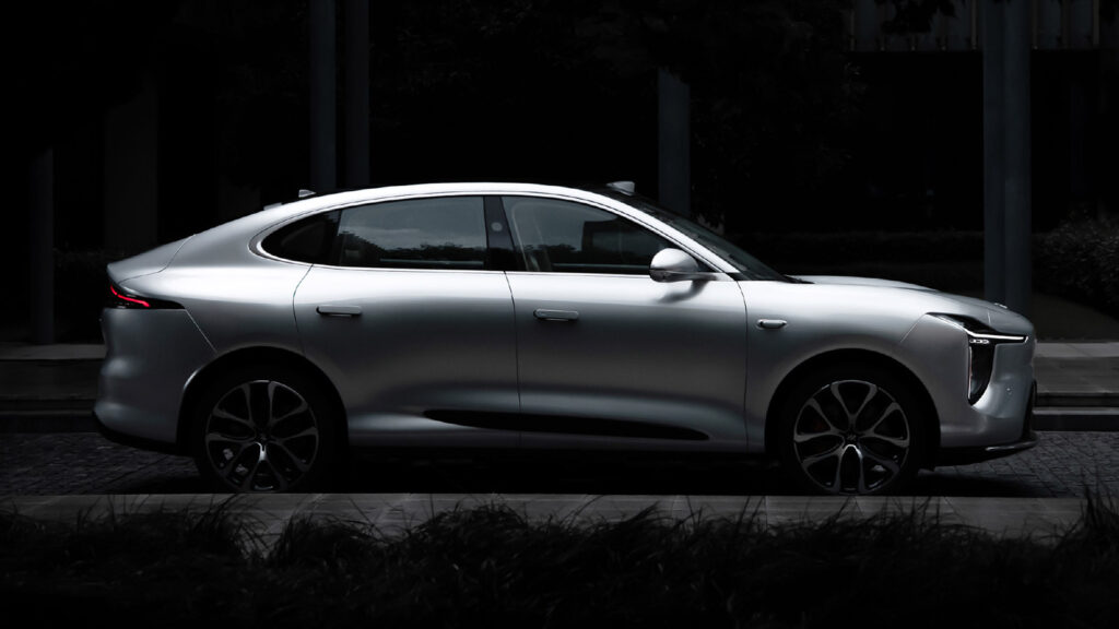 Side profile of the all-new silver IM LS6 SUV parked outside a building.