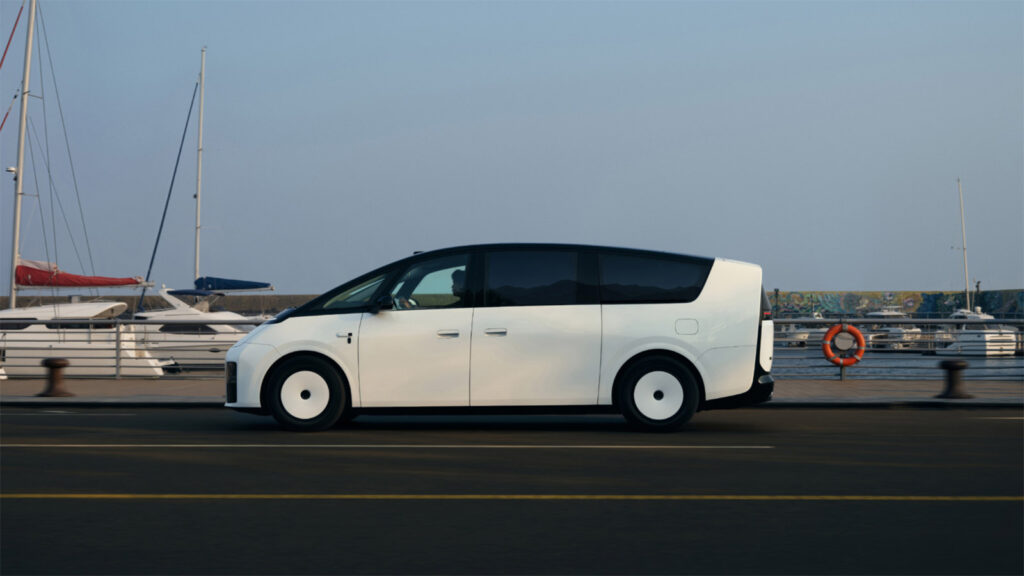Side view of a white new-generation Li Mega driving past yachts at a marina.