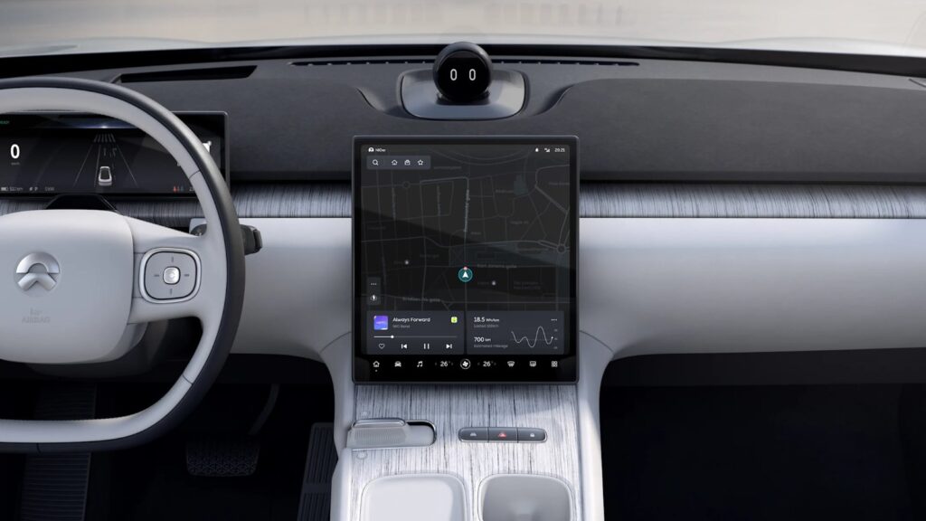 Nio extends HERE partnership beyond Firefly to full European lineup Nio vehicle interior with a navigation map on the central touchscreen and the NOMI assistant above the dashboard.