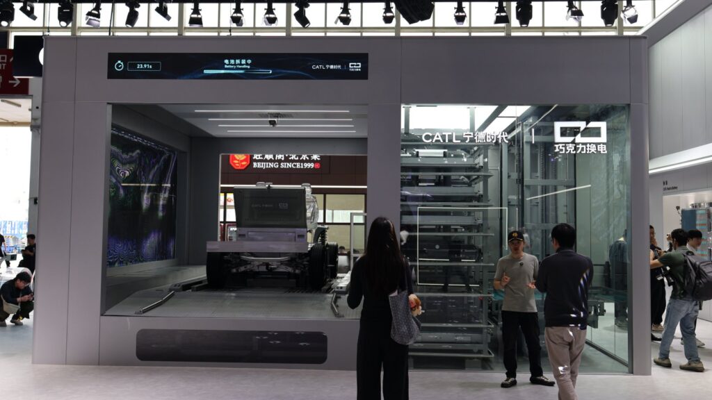 CATL Choco battery swap station with an exposed vehicle chassis and battery storage racks on display.